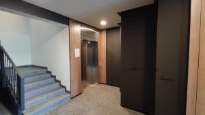 een hal met een trap en een deur en een trap bij Rybalsky Studio apartment Dnipro view in Kiev
