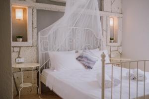 1 dormitorio con 1 cama blanca con dosel blanco en Deruni Ilıca en İzmir
