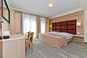 ブワディスワボボにあるWilla Domaroのベッドとデスクが備わるホテルルームです。