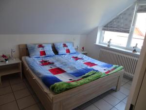 una camera da letto con un letto con un piumone blu e due finestre di 50108 Ferienhaus Cliner Sünn Whg. Baltrum a Carolinensiel