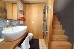 a bathroom with a sink and a toilet and a staircase at Nid d'Amour, le Nain. in Albinen