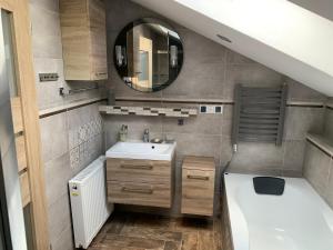 ein kleines Badezimmer mit Waschbecken und Spiegel in der Unterkunft Kanarek in Ustka + 36 Fotos