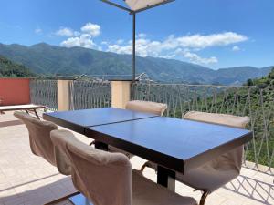 a table and chairs with a view of mountains at Le case della Lizza - Casa Rossa in Levanto