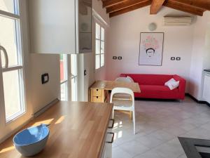 a living room with a red couch and a table at Le case della Lizza - Casa Rossa in Levanto +28 photos