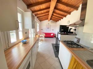 a kitchen with wooden ceilings and a living room at Le case della Lizza - Casa Rossa in Levanto
