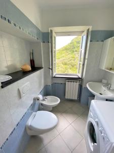 a bathroom with a toilet and a sink and a window at Le case della Lizza - Casa Rossa in Levanto