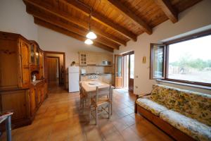 eine Küche und ein Wohnzimmer mit einem Sofa und einem Tisch in der Unterkunft L'oliveto in Nuxis