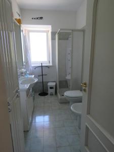 a bathroom with a sink and a toilet and a window at L'Elefantino - Bed and Book in Roccasparvera