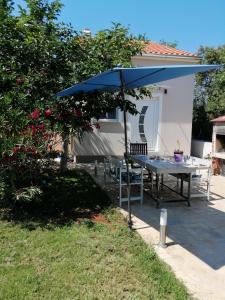einen Tisch mit einem blauen Regenschirm im Hof in der Unterkunft Casa Elysium in Rovinj