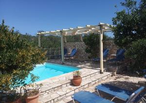 a swimming pool with a pergola and chairs around it at Paxos Bonzai Studios in Gaios