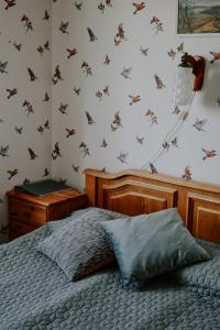 a bedroom with a bed with butterflies on the wall at Viesu nams Lauciņi in Lāde