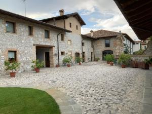 un patio de un edificio de piedra con macetas en Borgo Palazzo Steffaneo en San Vito al Torre