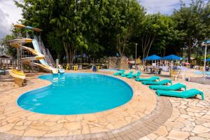 a swimming pool with a slide in a resort at Hotel Fazenda Pé da Serra in Bom Sucesso