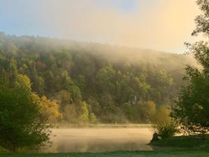 a misty mountain with a lake in the foreground at Idylle II an der Donau in Pentling