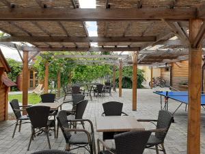 un patio con mesas y sillas y una mesa de ping pong en Apartments Vila Jurka, en Križevci pri Ljutomeru