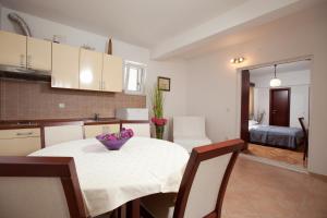 a kitchen with a table with a bowl of flowers on it at Agava Apartments Begic in Makarska