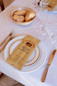 una mesa con un plato de comida y una cesta de pan en LA TANA DEL CINGHIALE, en Santa Vittoria in Matenano