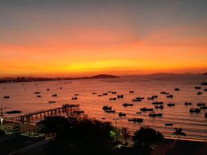 a group of boats in the water at sunset at Pousada Vila de Monaco in Penha +37 photos