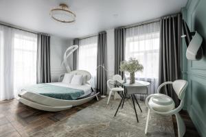 a bedroom with a bed and a table and chairs at Apart-Hotel on Pushkina 26 in Kazan