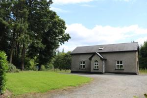un pequeño edificio gris con un patio de césped en Castlehamilton Cottages and Activity Centre, en Cavan