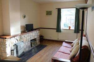sala de estar con chimenea y sofá en Castlehamilton Cottages and Activity Centre, en Cavan