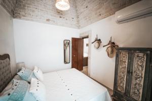 - une chambre avec un lit et un mur en briques dans l'établissement Trullo Malvasia-Trulli Antì Charme & Relax, à Alberobello