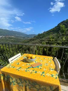 una mesa con un mantel amarillo en el balcón en Le case della Lizza - Casa Gialla, en Levanto