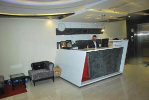 a man is standing at a counter in a lobby at AS Clarks inn in Dalhousie