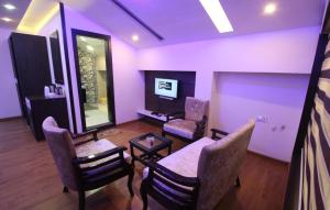 a living room with chairs and a table and a mirror at AS Clarks inn in Dalhousie