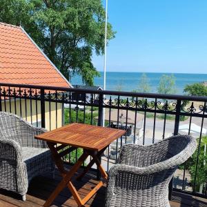 a patio table with chairs and umbrellas on top of it at STF Kivikstrand Badhotell in Kivik