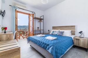 una camera con un grande letto e un balcone di Nepheles a Skopelos Town
