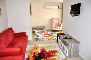 a living room with a red couch and a table at Neoss Boutique Hotel in Siğacık