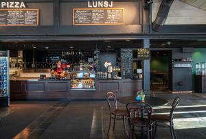 a restaurant with a table and chairs and a bartender at Skeikampen Servicesenter in Svingvoll