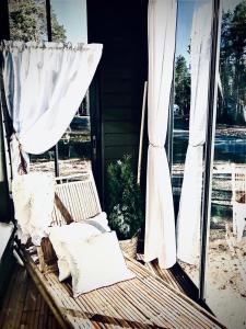 a porch with a chair and a window with curtains at Kalajoen Hiekkasärkät Auringonsäde A1 in Kalajoki