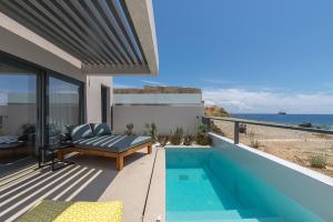 a house with a balcony with a pool and the ocean at Orion suites in Tinos