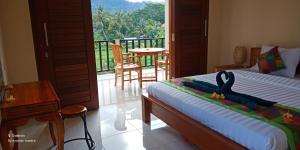 a bedroom with a bed with a toy penguin on it at Mantra Guesthouse Sidemen in Sidemen