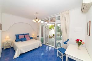 Schlafzimmer mit einem Bett, einem Tisch und Stühlen in der Unterkunft Casa Maresca Residence in Positano