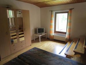1 dormitorio con 1 cama, TV y ventana en Chata pod Dubákom, en Lazisko