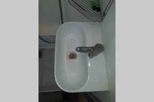 a white sink in the corner of a bathroom at Air conditioned STUDIO in quite garden with barbecue Athens in Athens +7 photos