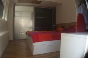 um quarto com uma cama grande e um cobertor vermelho em Entire Studio in quite garden with barbecue Athens em Atenas