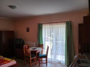 a dining room with a table and a window at Balla Appartements in Zalakaros