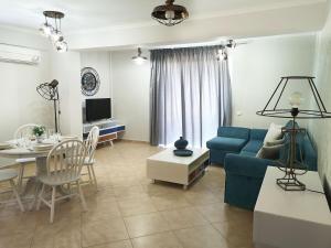 a living room with a blue couch and a table at Pirofani Villa Apartments in Apolpaina