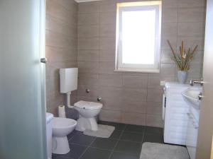 un bagno con un water, un lavandino e una finestra di Apartment Goran a Krk Altre 22 foto