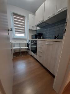 cocina con armarios blancos y lavavajillas en Sophia's Cozy Apartment, en Mediaş