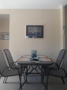 a dining room table with four chairs and a television at Jimmys Nature House in Metamorfosi