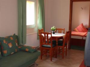 a living room with a table and chairs and a bed at Balla Appartements in Zalakaros