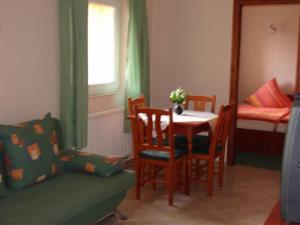 uma sala de estar com uma mesa e cadeiras e uma cama em Balla Appartements em Zalakaros