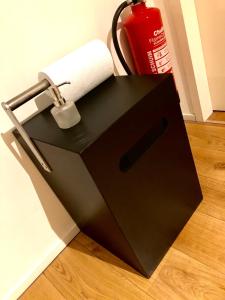 uma caixa preta com um rolo de papel higiénico no chão em accademia00 em Maastricht