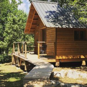 una cabaña de madera con una rampa de madera que conduce a ella en Lodge du Berlandou, en Escragnolles