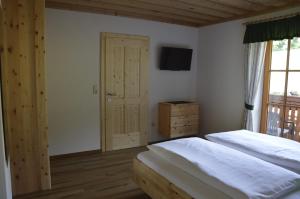 a bedroom with two beds and a television on the wall at Haus Stückler in Steinbach am Attersee